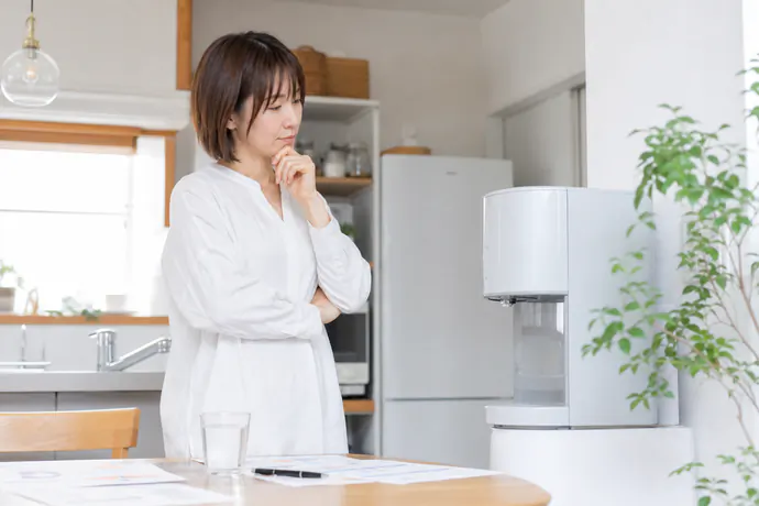 キッチンで浄水型ウォーターサーバーが家庭に合うか確認している様子