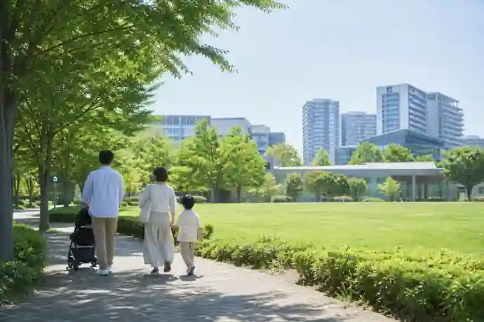 柏の葉公園の緑地と近隣の街並みを家族が歩いている場面