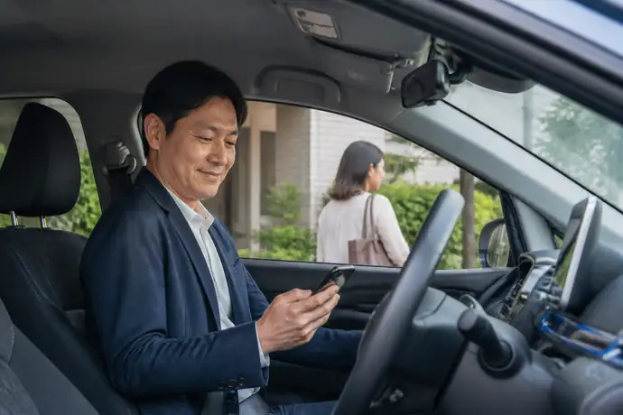 乗客を安全に迎え、アプリの評価や働き方を振り返るライドシェアドライバーの場面