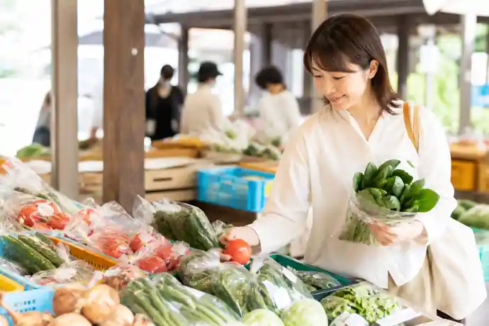 松戸の農産物直売所で利用者が旬の野菜と持ち帰り量を選んでいる場面