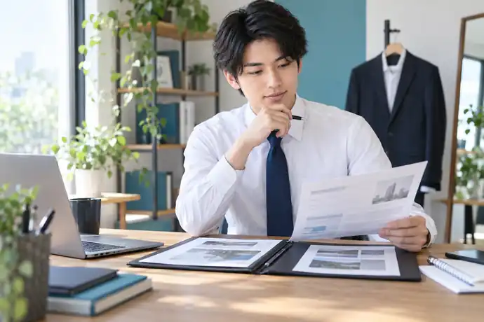 応募先の求人票とポートフォリオを並べ、面接で話す経験を整理している場面