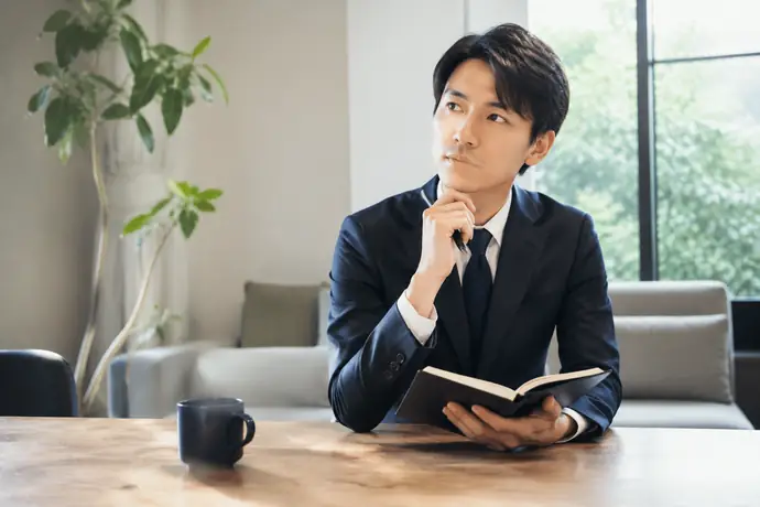 面接室で応募者がメモを見ながら、入社後の役割について質問を準備している場面