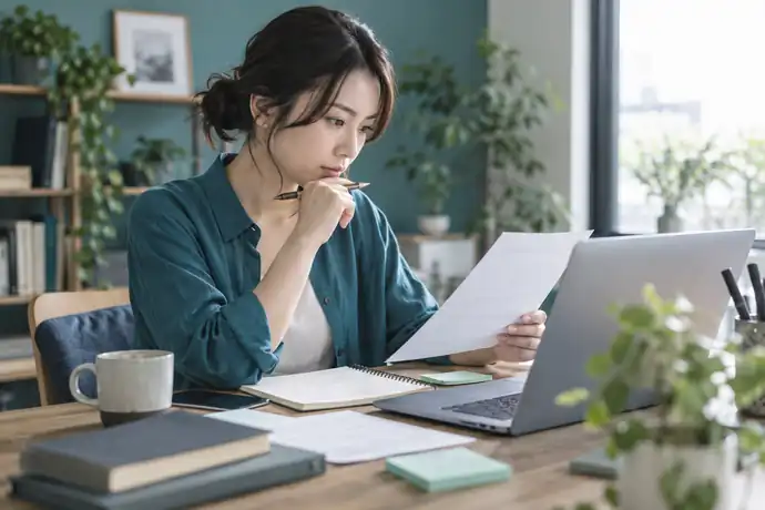 追加作業の内容と見積金額を落ち着いて確認している、フリーランスの仕事机の場面