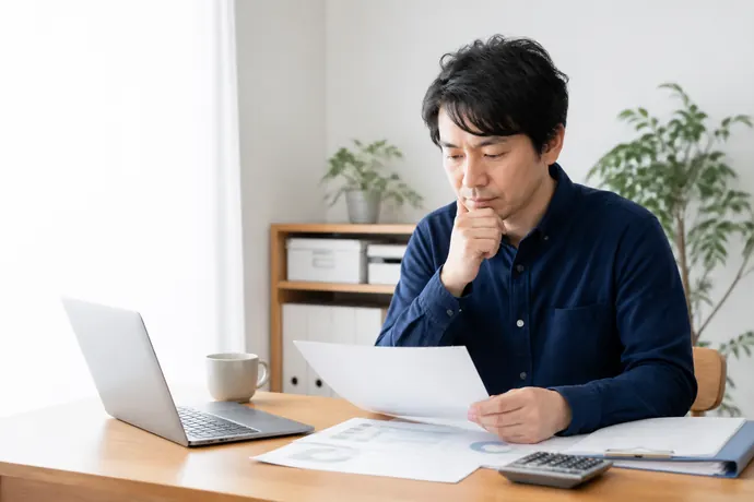 医療費負担を抑える「国民健康保険組合(国保組合)」の活用条件の内容を確認する個人事業主の自然な仕事風景