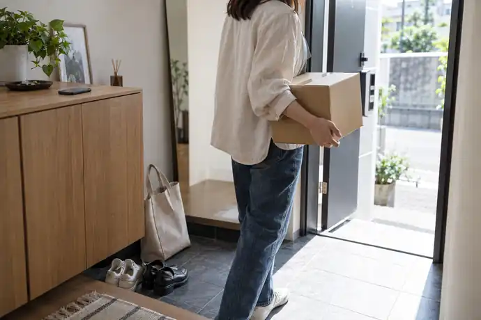 集荷依頼を持ち込みに切り替え、箱を持って玄関から出る人